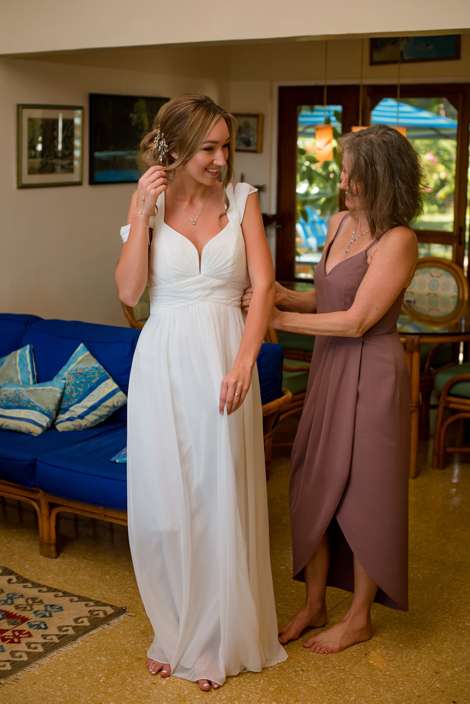 White wedding dress being fitted in a casual living room setting.