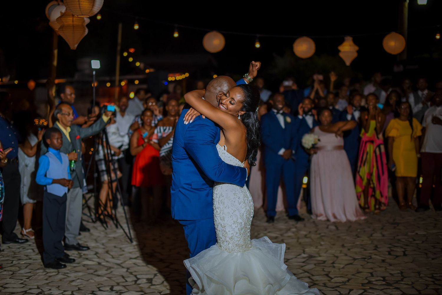 Crowd of wedding attendees enjoying a nighttime beach celebration.