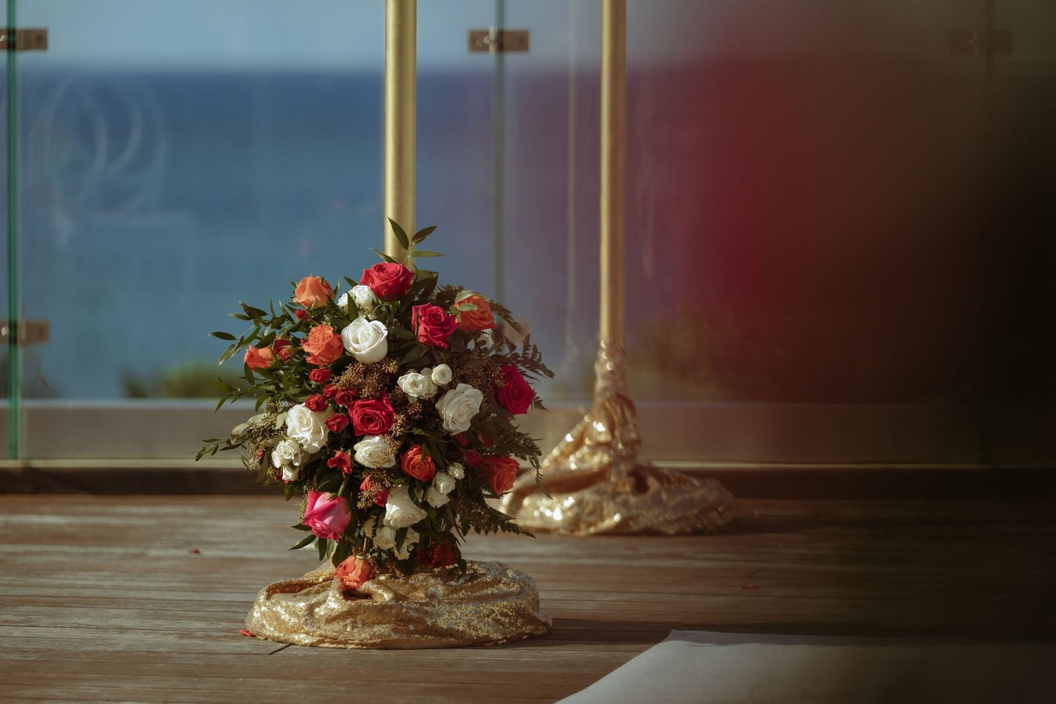 Elegant floral arrangements with red and white roses decorate a wedding venue.