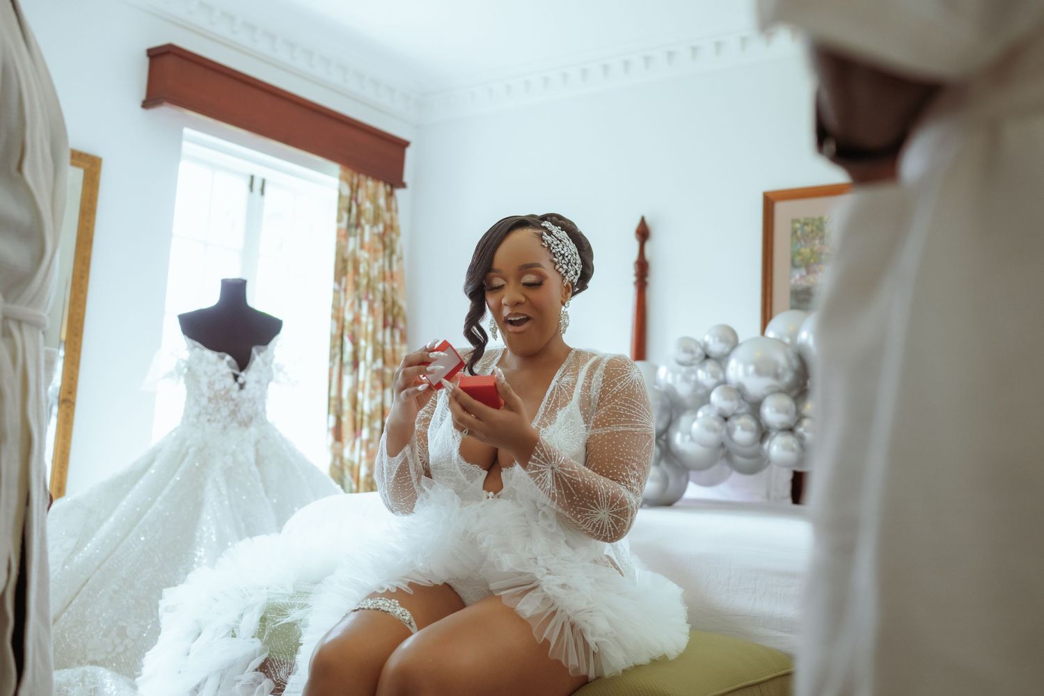 Elegant white wedding gowns displayed in a bridal boutique with ornate decor and soft lighting.