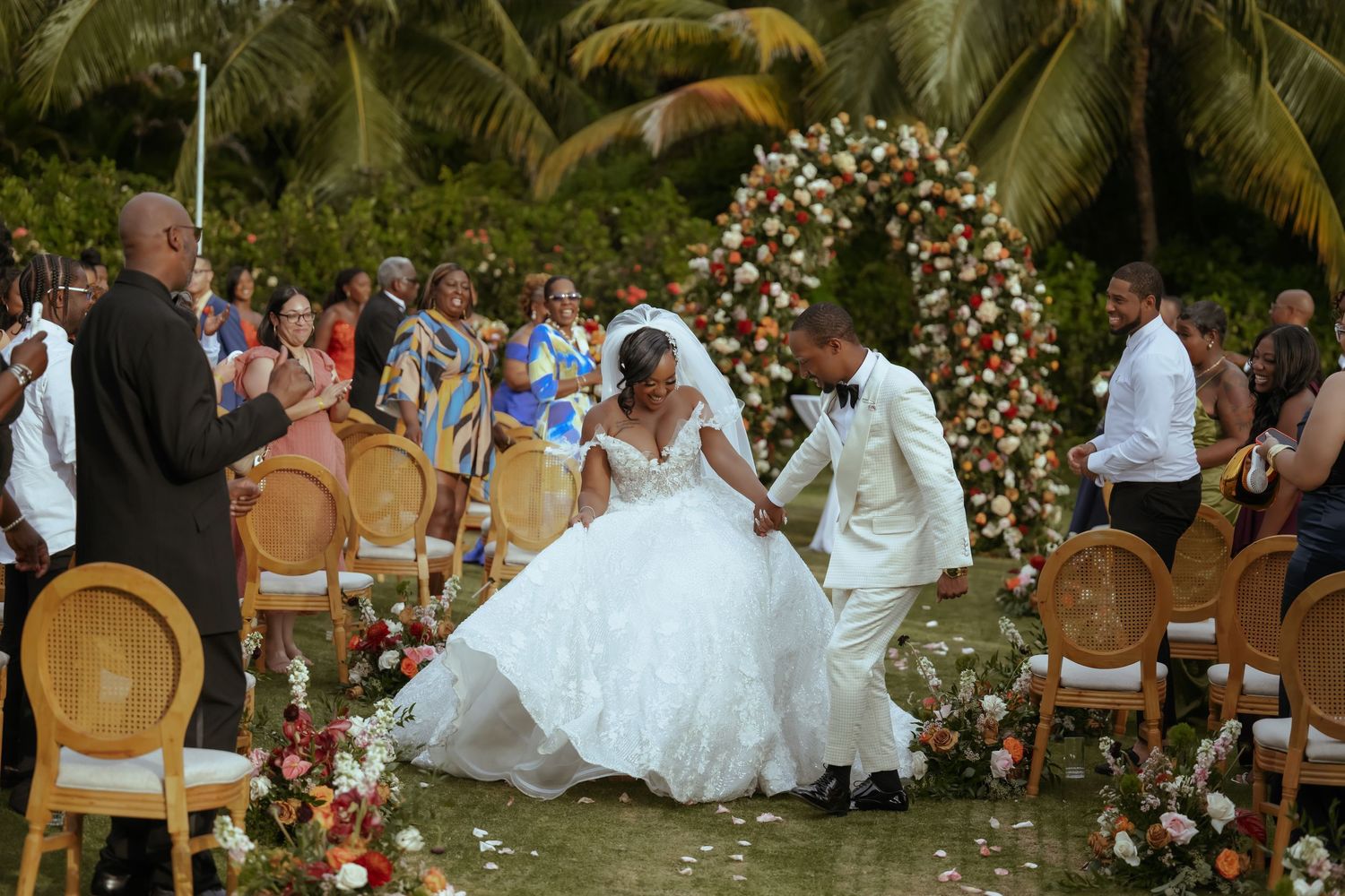 Garden wedding ceremony with tropical palm trees and elegant floral arrangements.