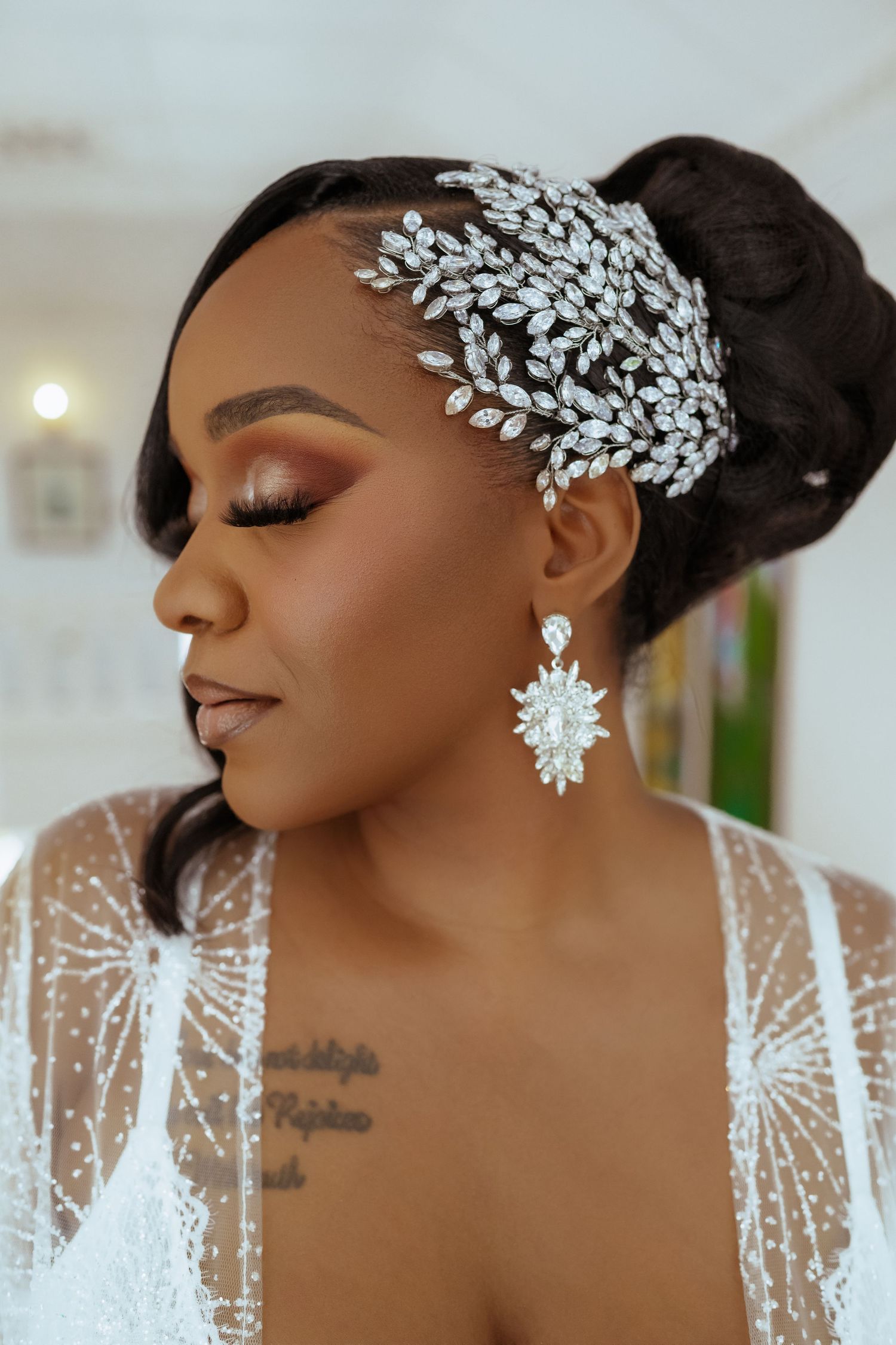 A stunning bridal beauty shot featuring crystal hair accessories and dramatic makeup.