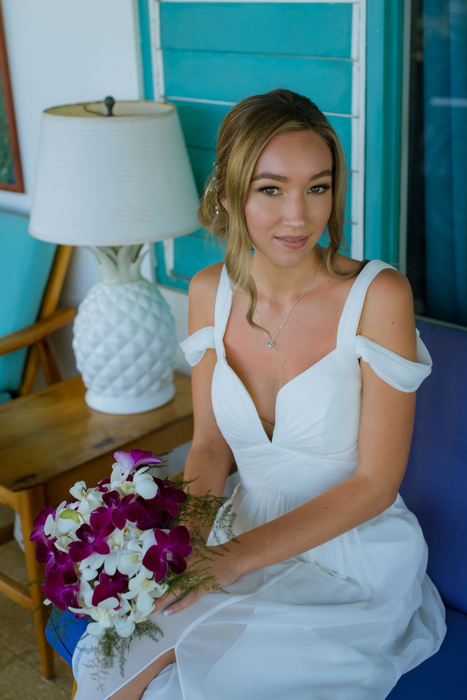 Bridal portrait with purple and white bouquet in coastal-themed setting.