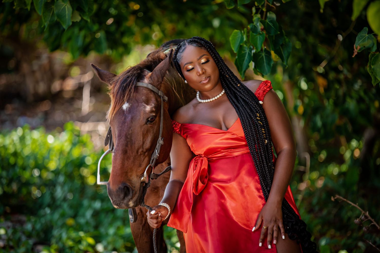 Person in coral dress poses elegantly in a lush tropical garden setting.