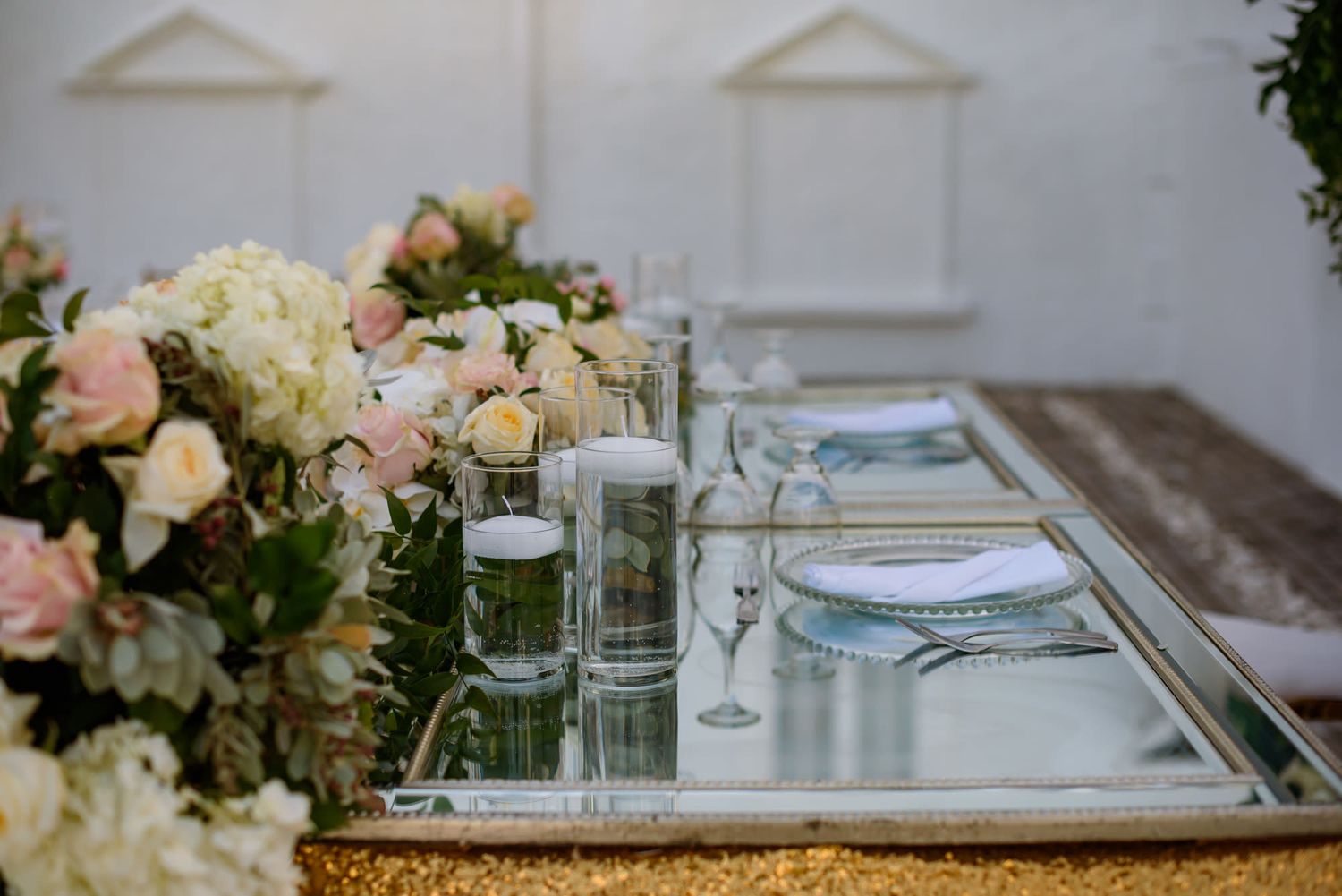Close-up of wedding table settings with crystal glassware and delicate floral arrangements.