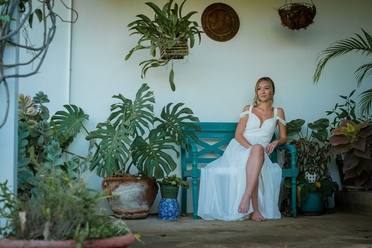 Wedding preparations in a tropical setting with indoor plants and white decor.