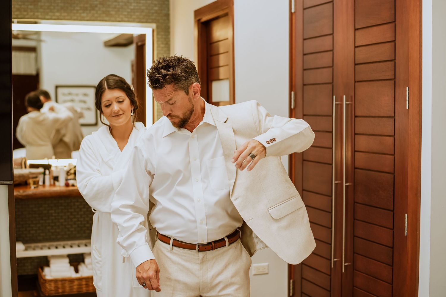 Pre-wedding moments captured in a room with wooden shutters and natural lighting.