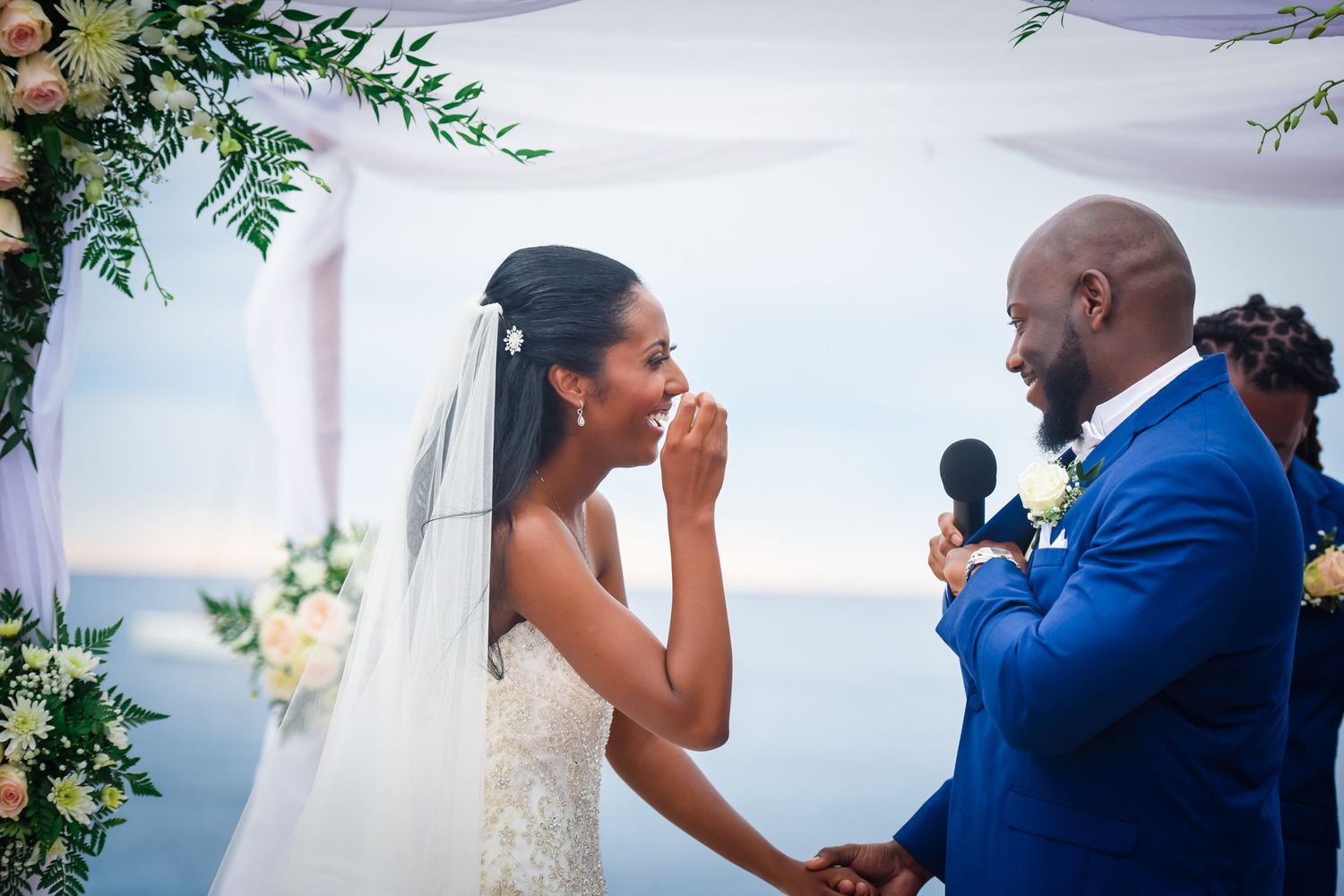 Emotional reactions during wedding vow exchange at waterfront ceremony.