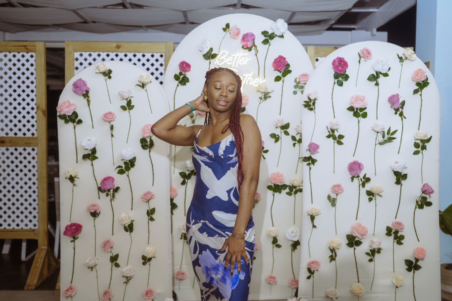 A series of photos showing someone posing in front of a floral backdrop with pink flowers and green stems painted on white walls.