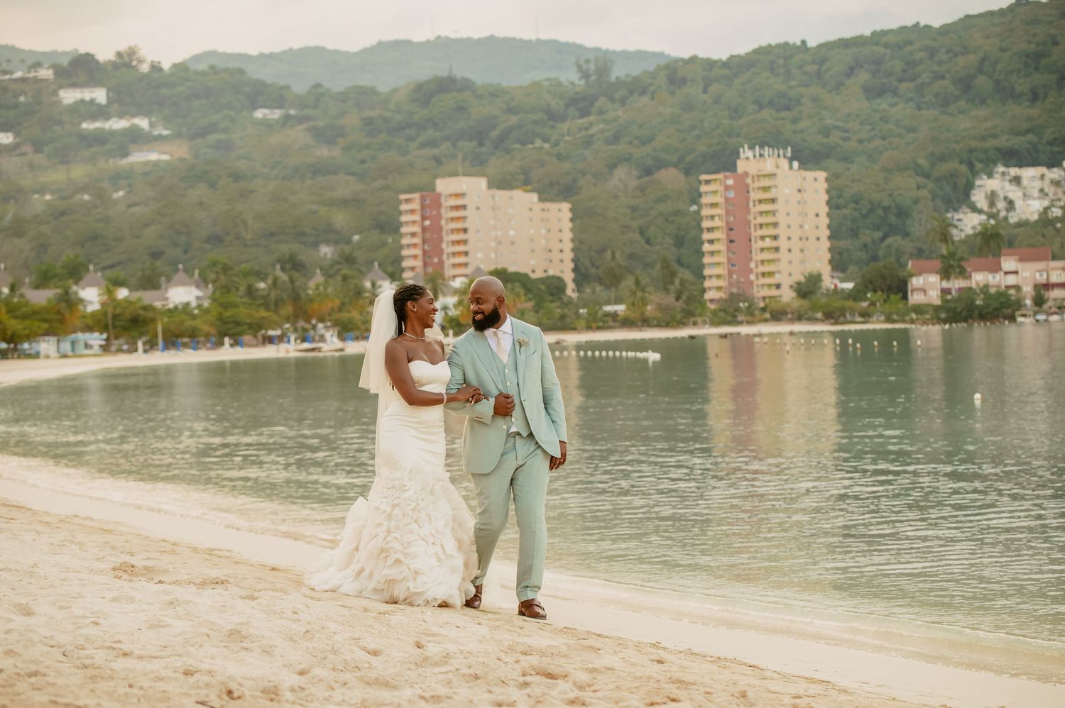 A scenic waterfront wedding location with mountains and buildings in the background.