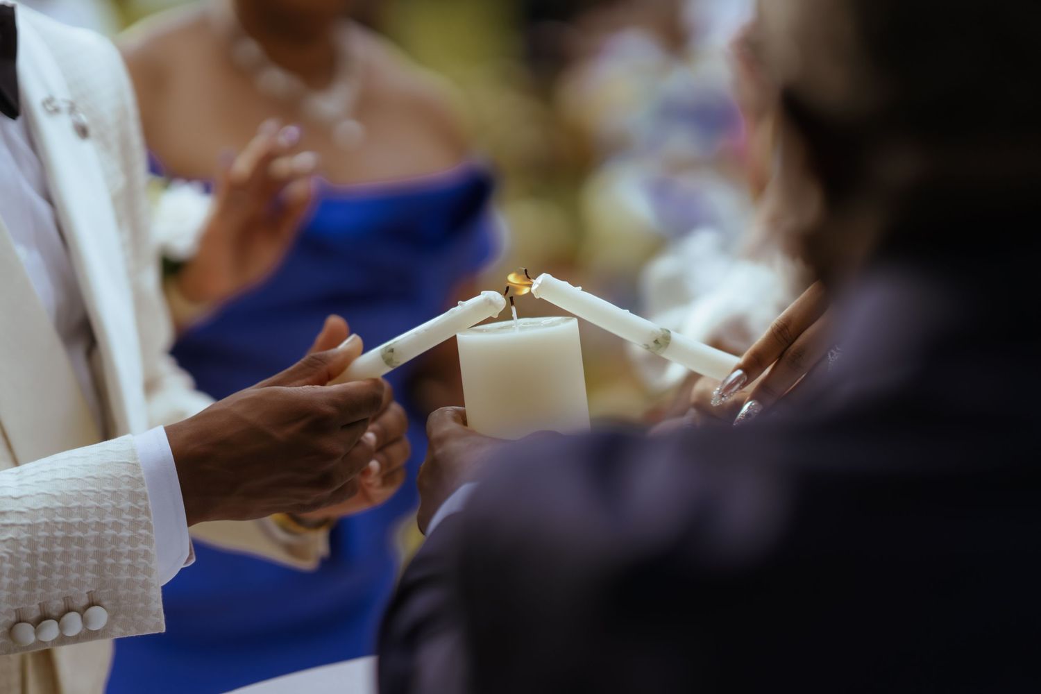 Wedding guests in formal attire gathered at tables during an indoor reception celebration.