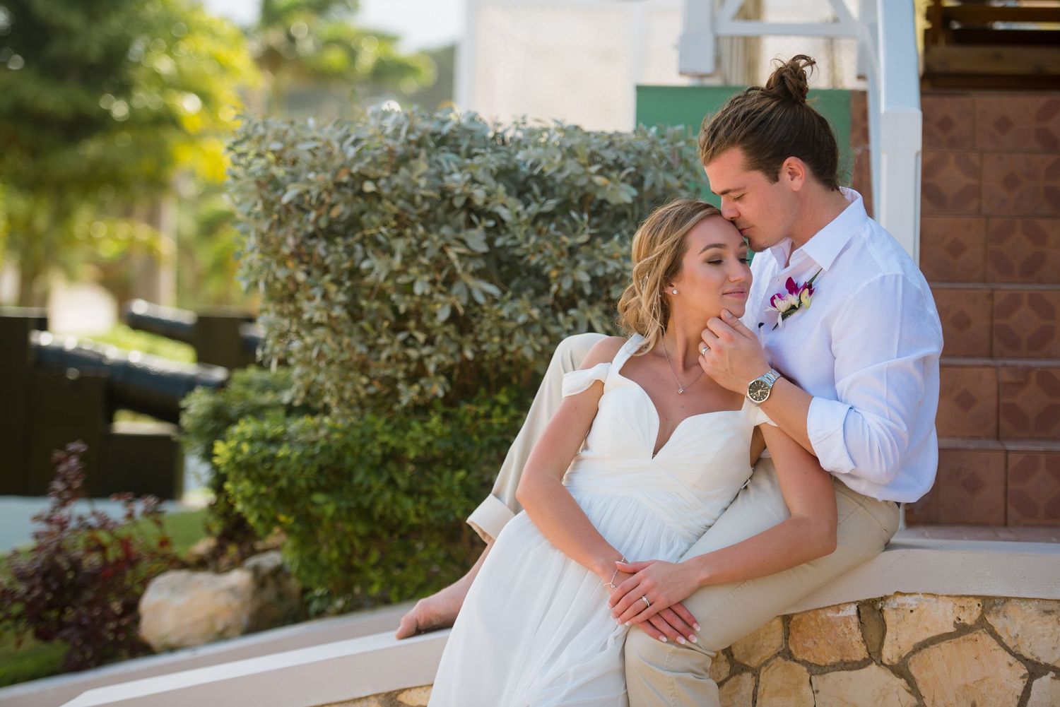 Romantic wedding portraits captured against rustic stone and brick wall backdrop.