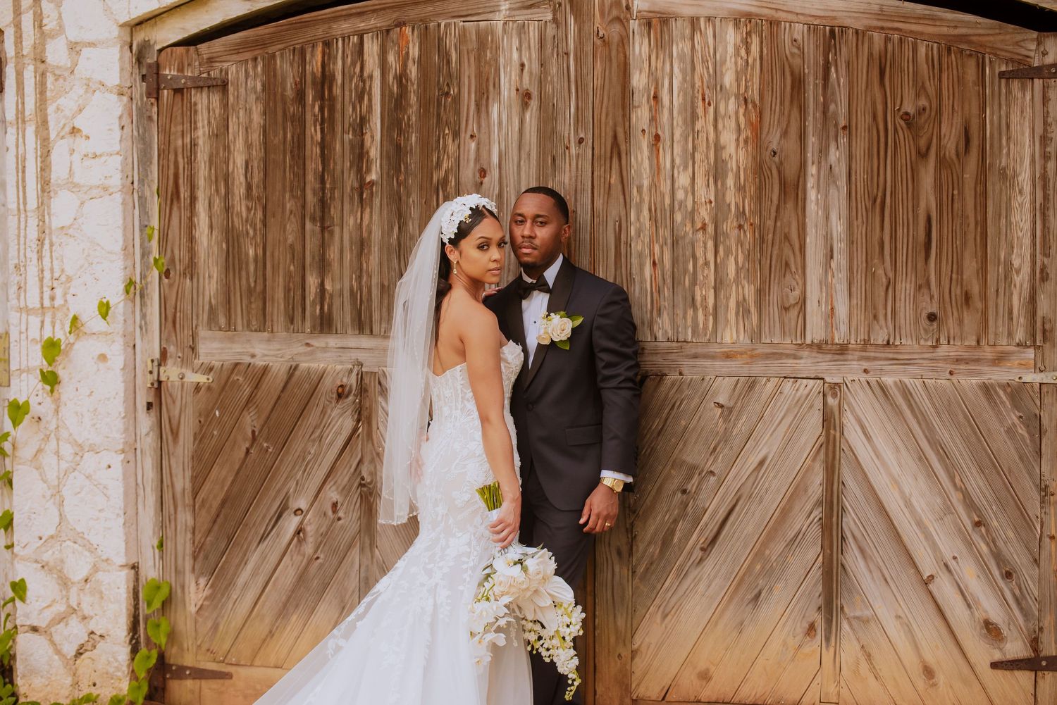 Romantic wedding portrait against rustic wooden barn doors.