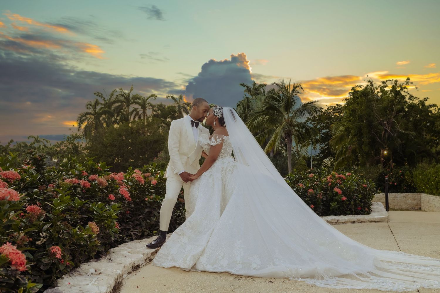 Sunset wedding photography session with palm trees and tropical flowers in the background. Luxury wedding photography at Half Moon Jamaica