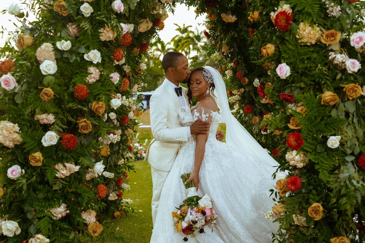 Romantic outdoor wedding scene with abundant floral arrangements in white, red and orange. Luxury wedding photography at Half Moon Jamaica
