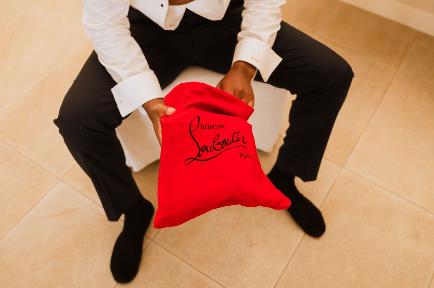 Groom's red Christian Louboutin shoes photographed during wedding preparations.