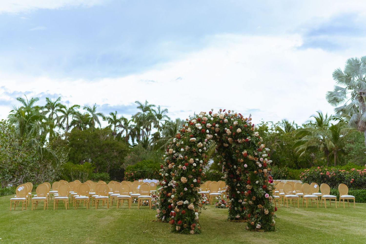 A panoramic view of a lush garden with colorful rose and flowering plants under a cloudy blue sky. Luxury destination wedding at Half Moon