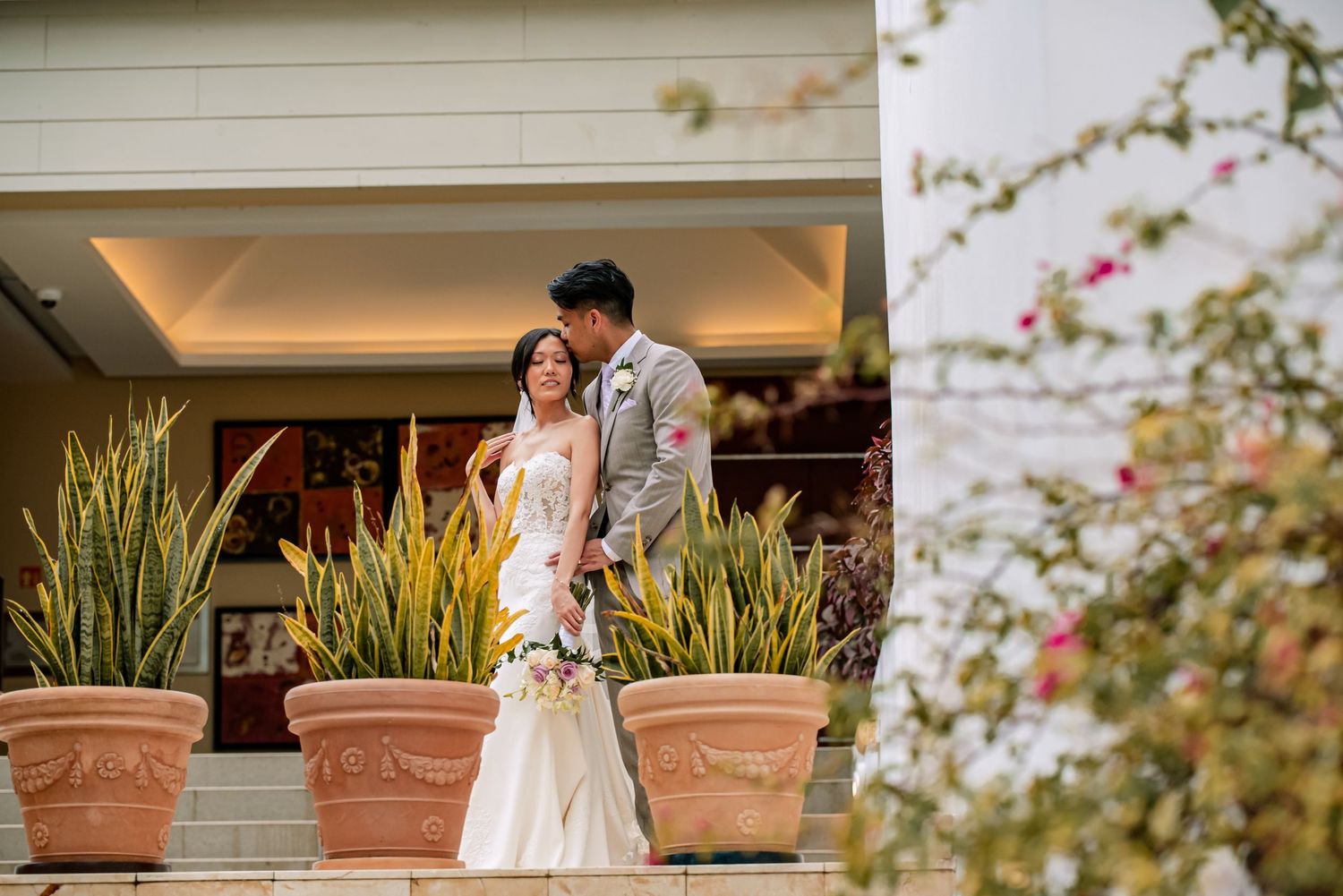 Outdoor wedding portraits with terracotta planters and natural garden backdrop.