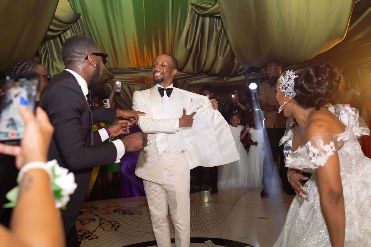 Wedding reception dance floor moments captured under elegant green and white decor.