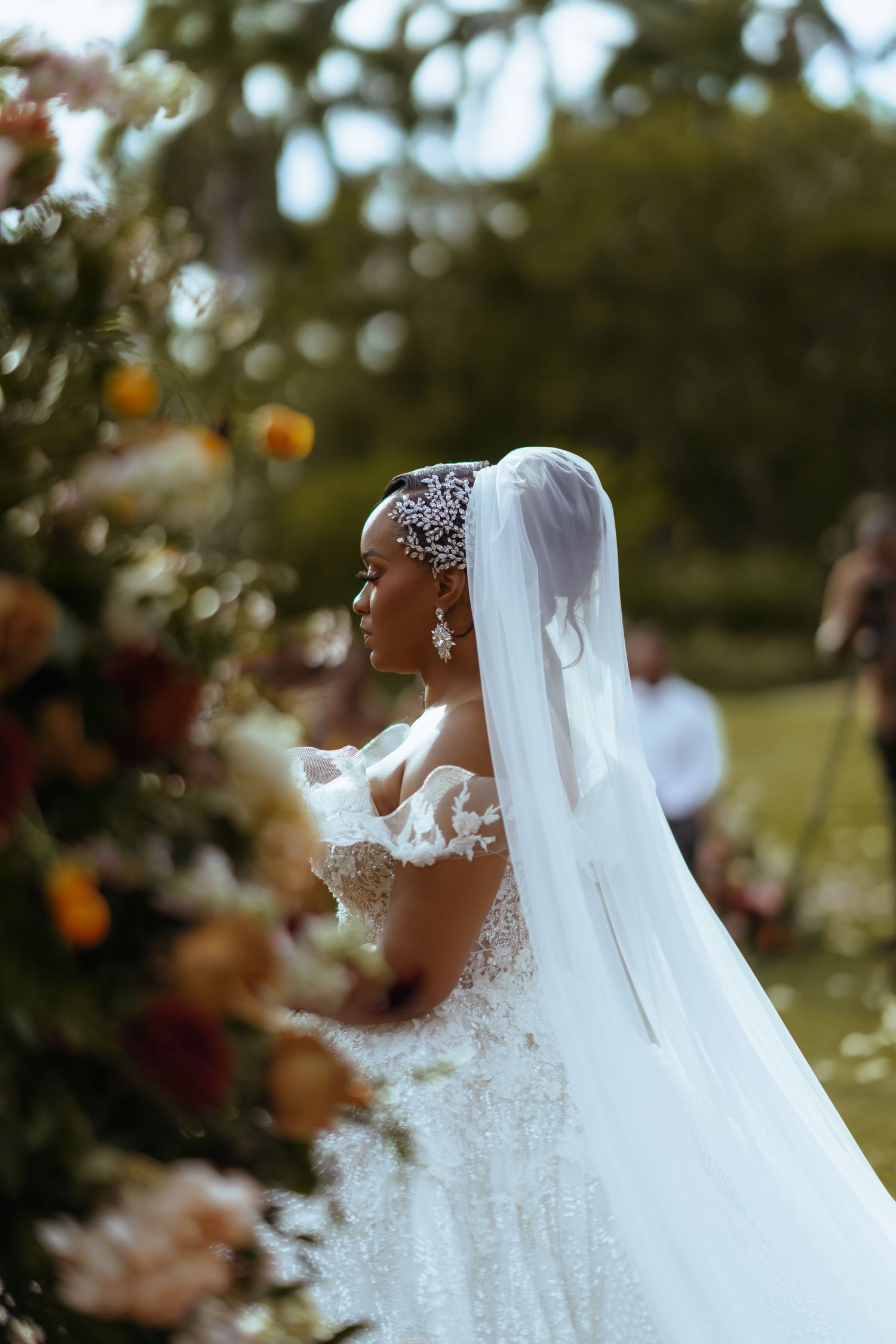 Close-up detail of an ornate white wedding dress with delicate lace patterns.