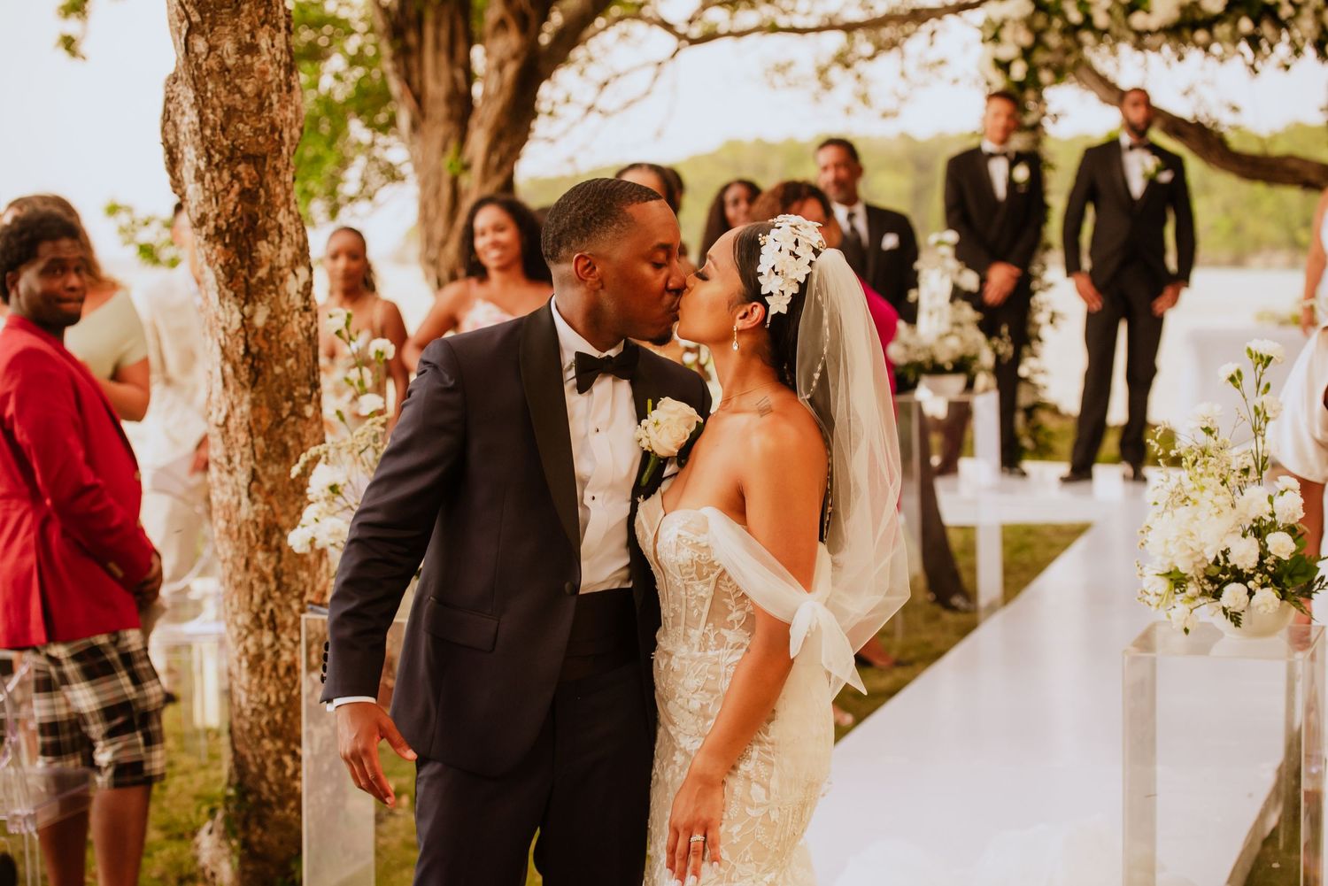 Wedding celebration outdoors with decorative white flowers and natural landscaping.