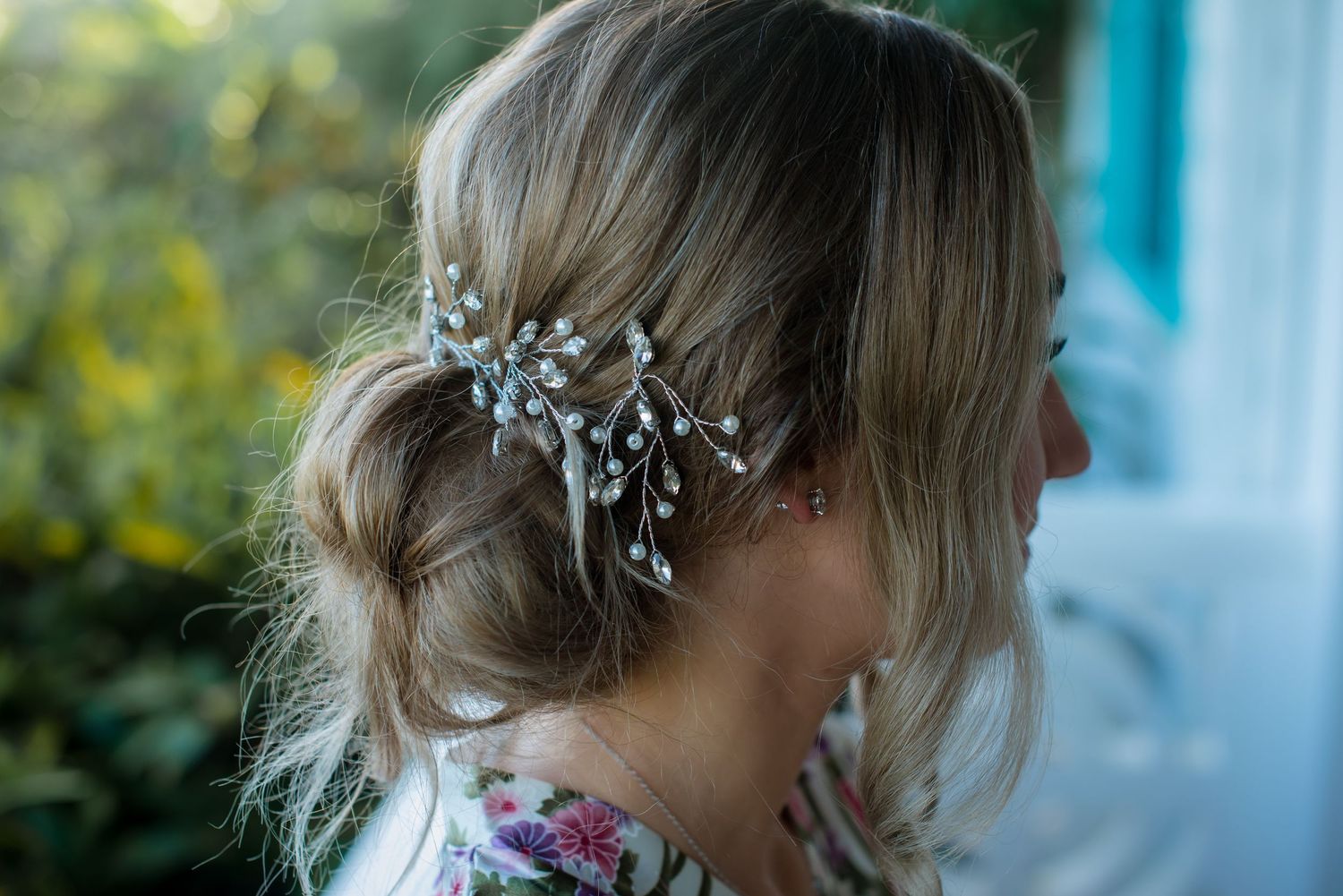 Elegant bridal hair accessories and styling details against soft blue background.