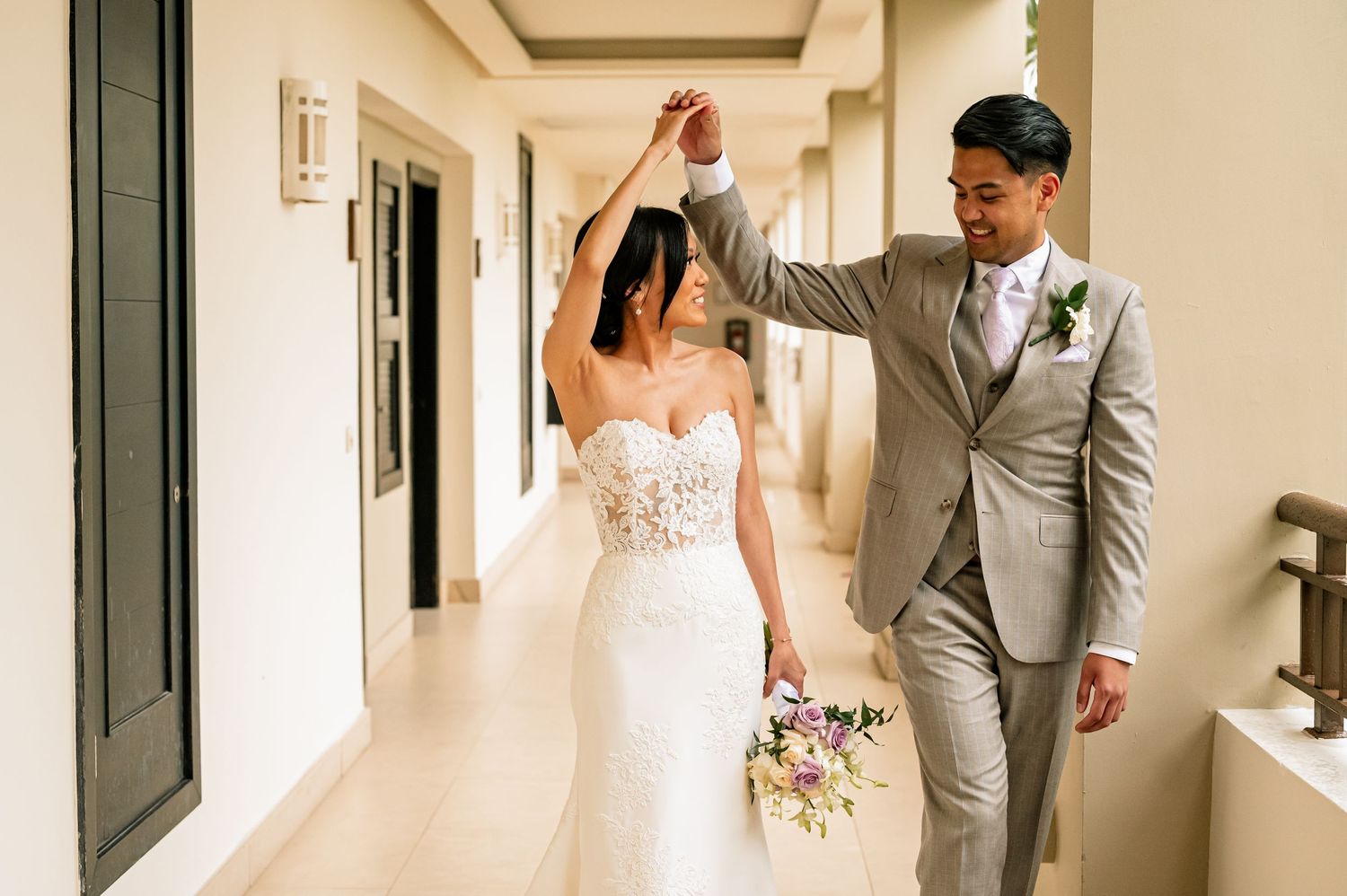 Wedding couple shares their first look moment in an elegant corridor.