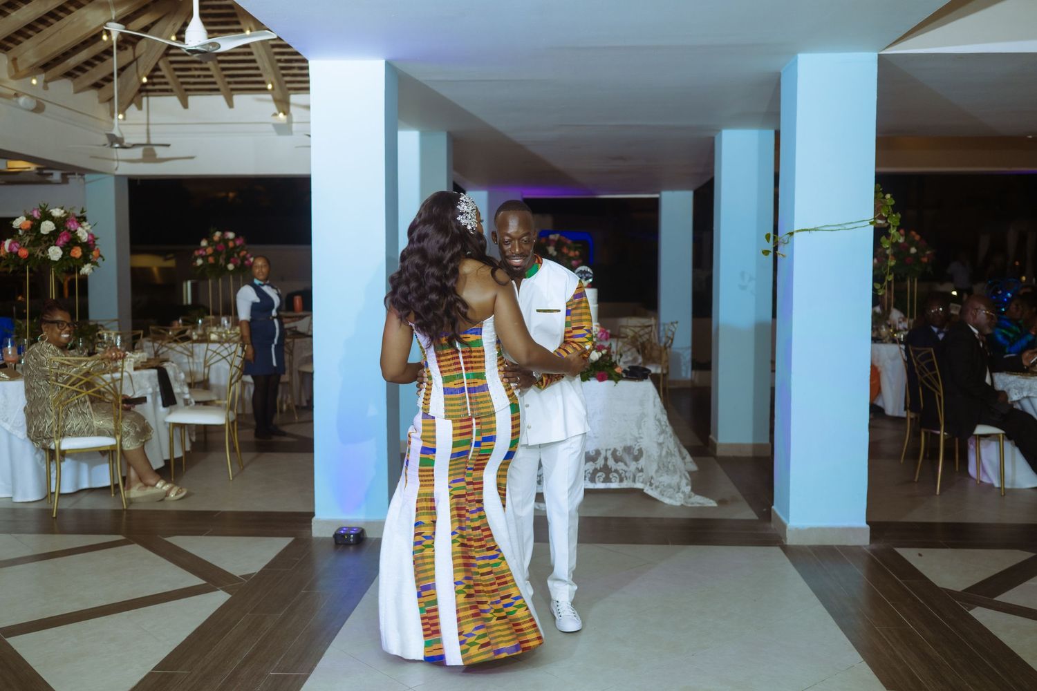 Indoor wedding reception venue with white and gold decor elements.