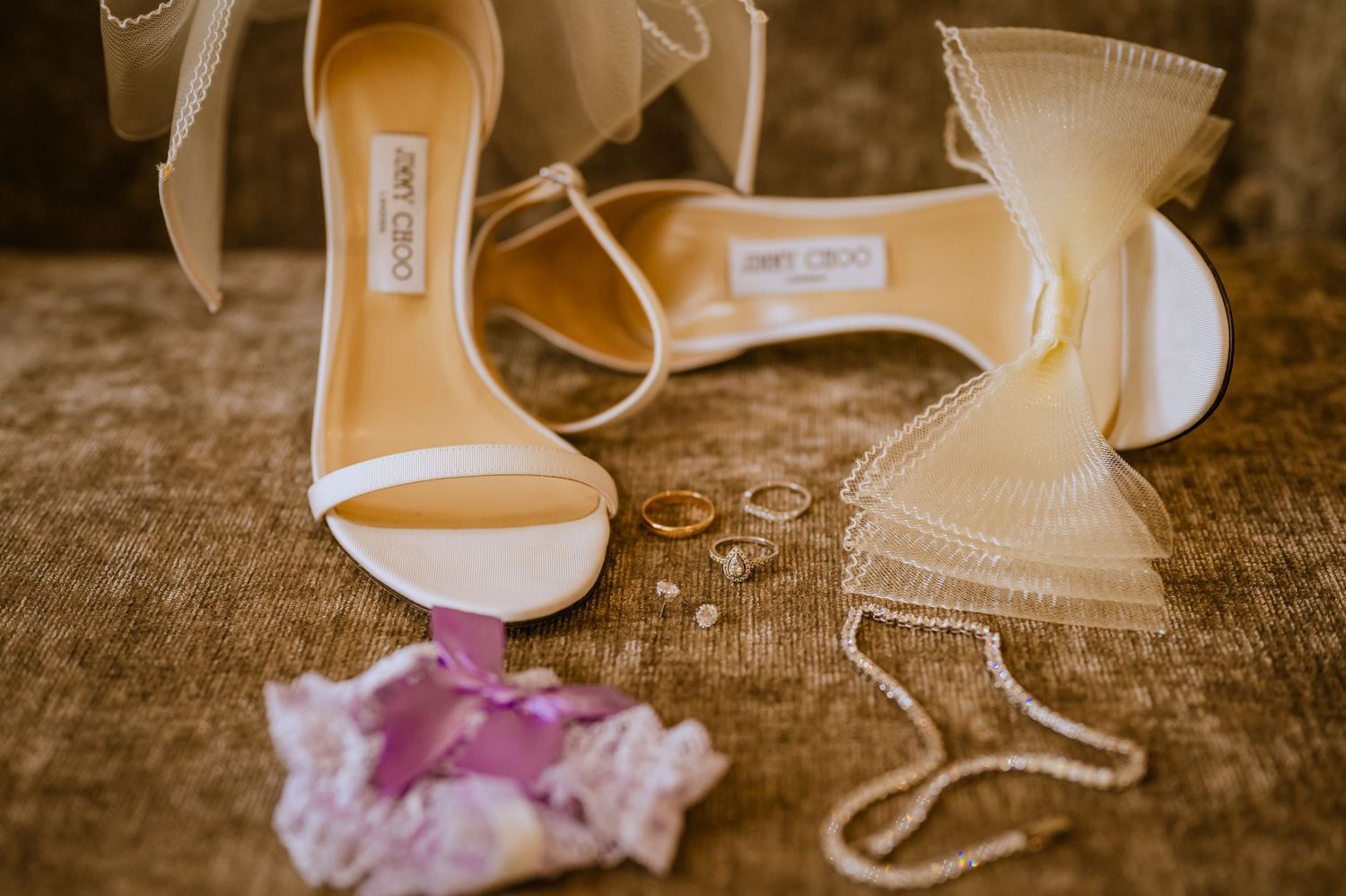 Sepia-toned detail shot of bridal shoes and accessories.