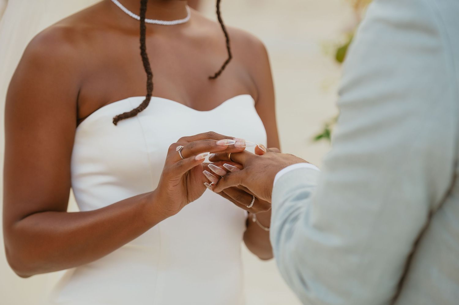 Close-up of bride's hands during an emotional wedding ceremony moment.