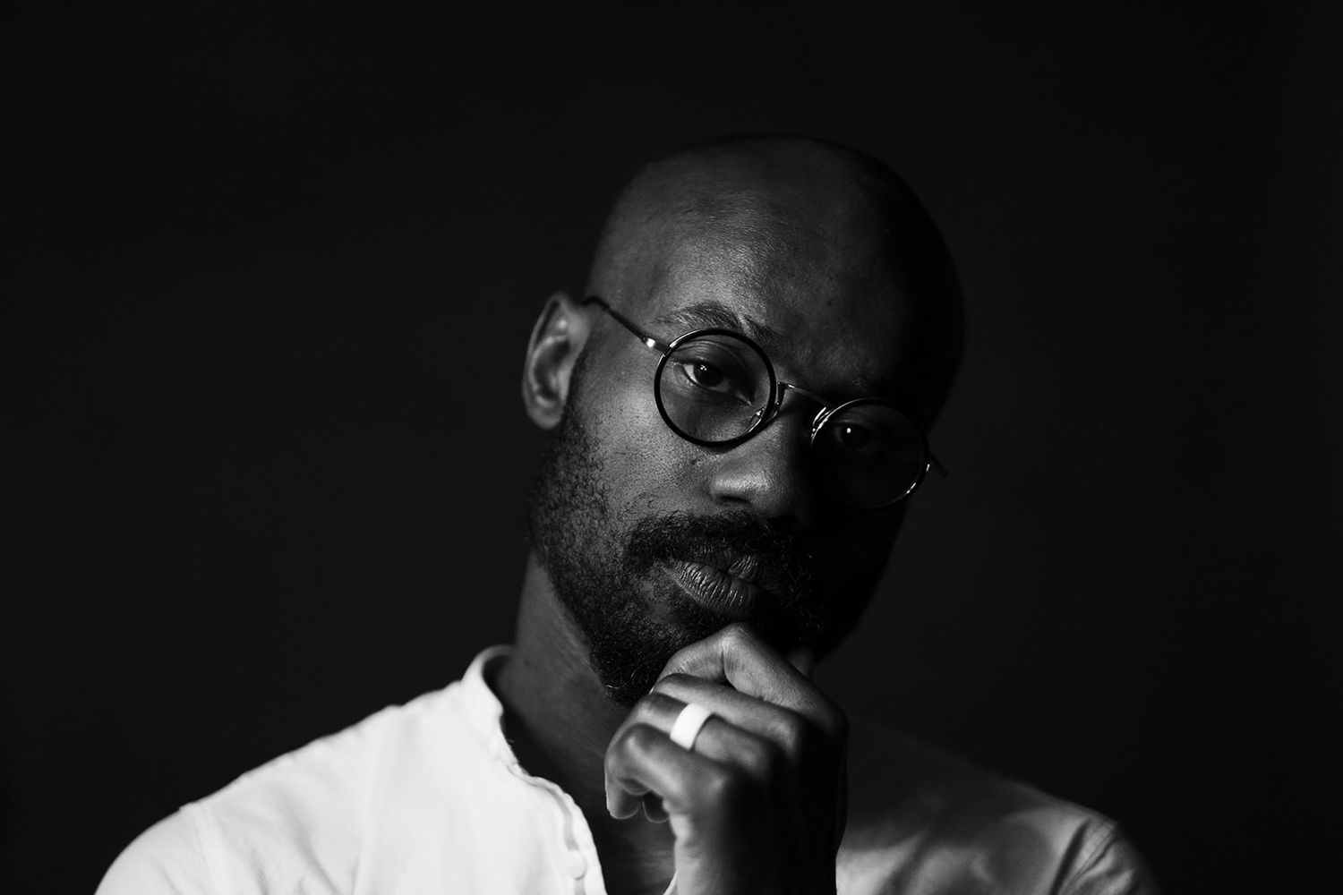 Dramatic monochrome photographic sequence showing various angles of someone wearing glasses in dark lighting.