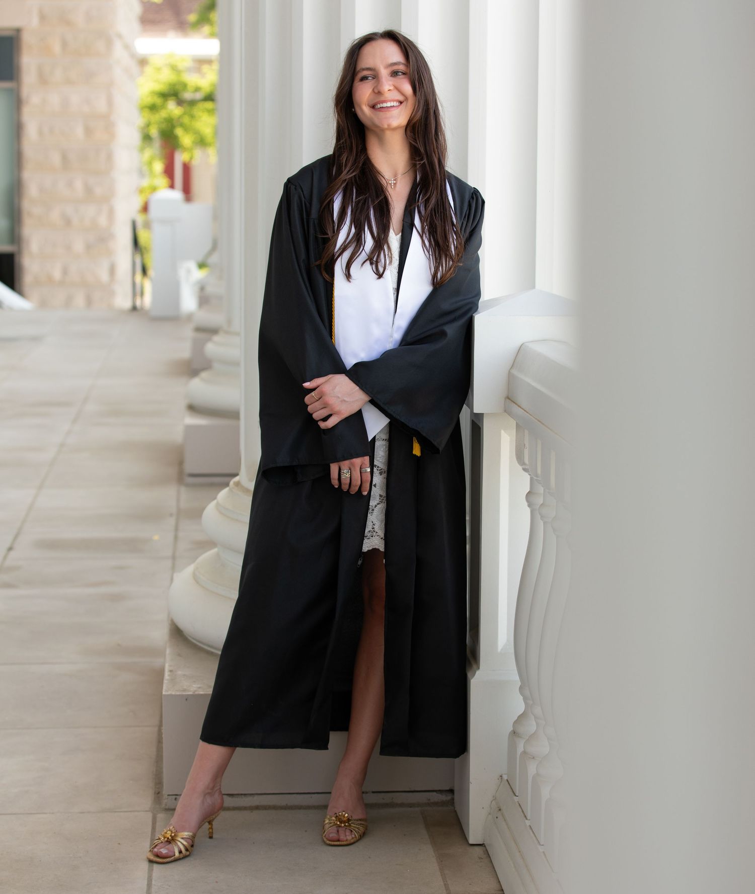 Professional look with black blazer walking through elegant white columned corridor.