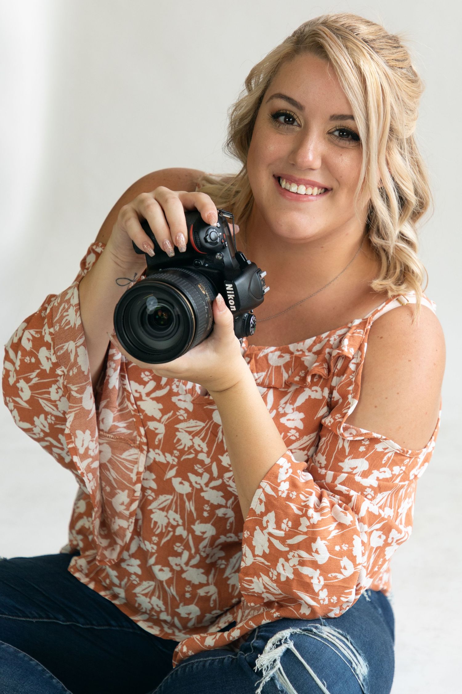 Professional photographer with camera taking creative portraits in a bright studio setting.