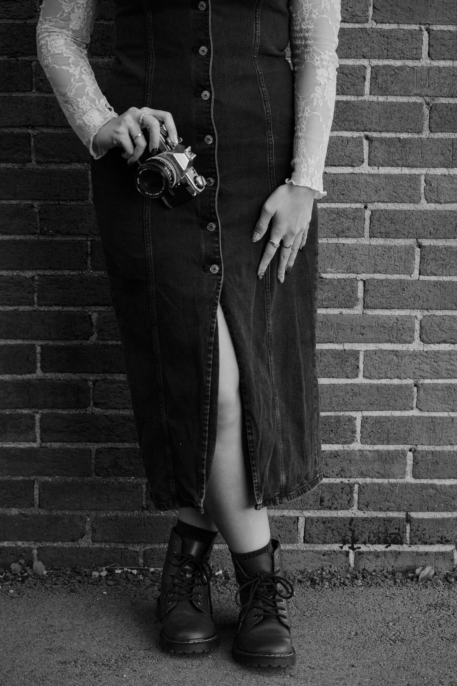 Black and white photo series showing close-up details of shoes and skirt against brick wall.