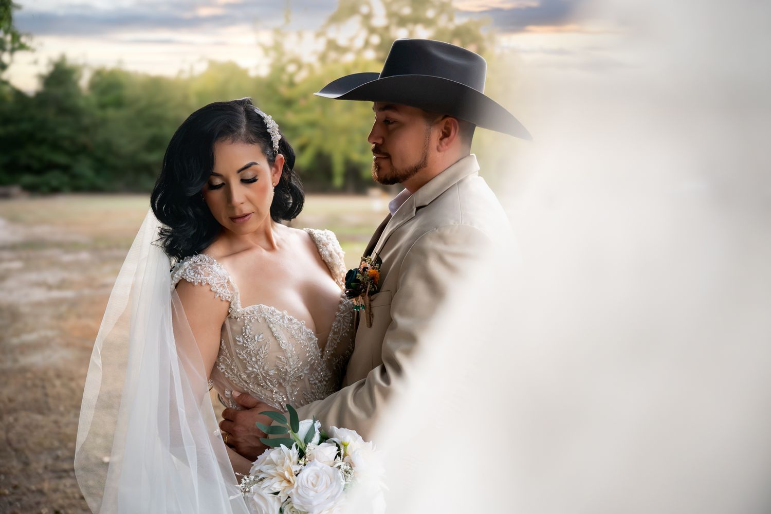 Bride and groom sharing intimate moment at sunset outdoor country wedding.