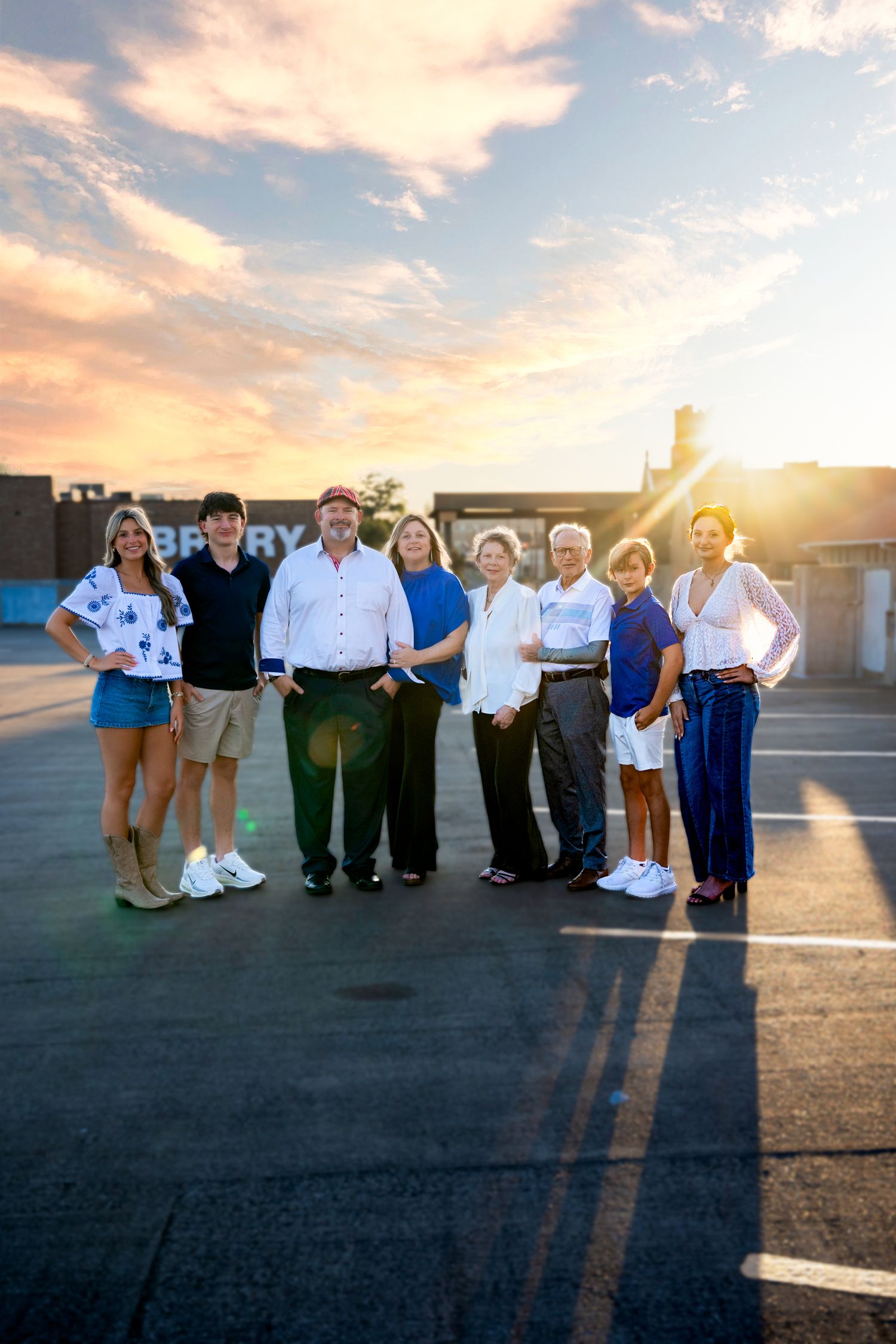Family group portrait at golden hour sunset on rooftop parking lot.