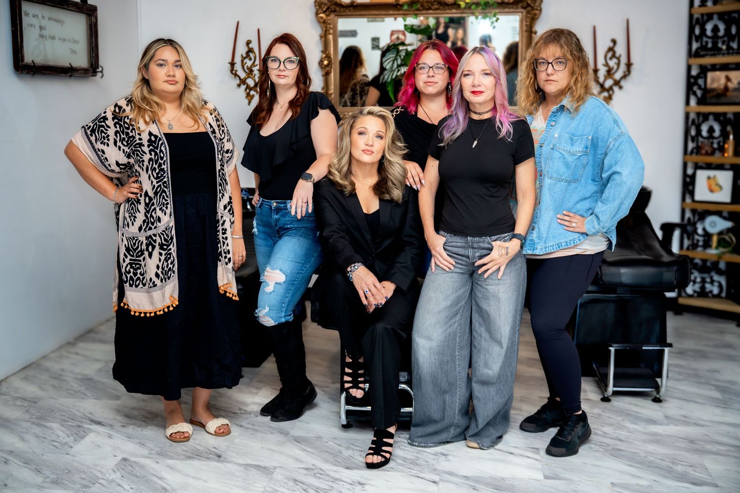 Professional hair salon team posing together inside stylish beauty salon studio.