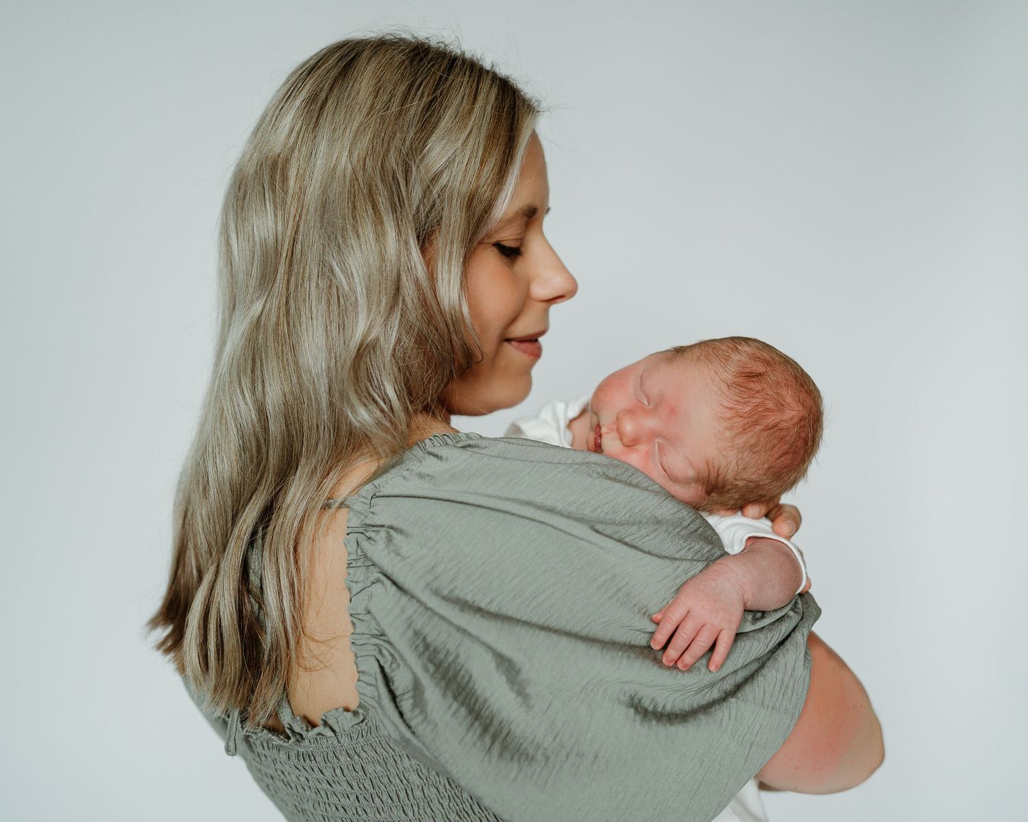 A couple in soft grey clothing share intimate embraces together in a series of tender profile shots.