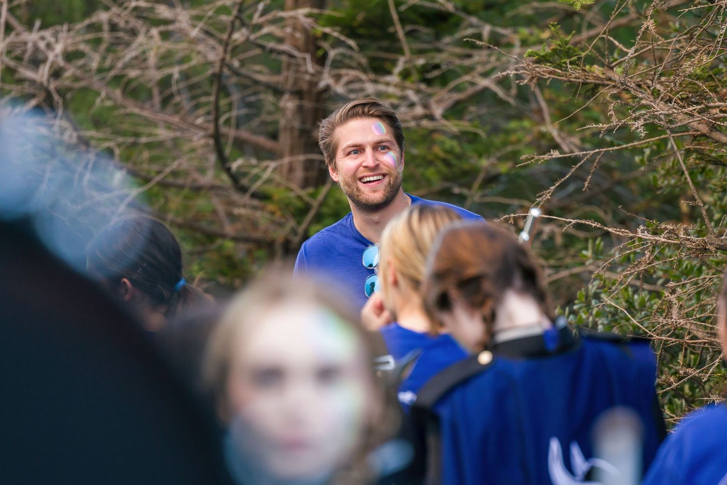 Group of children and adults on a field trip exploring nature and observing wildlife together outdoors.