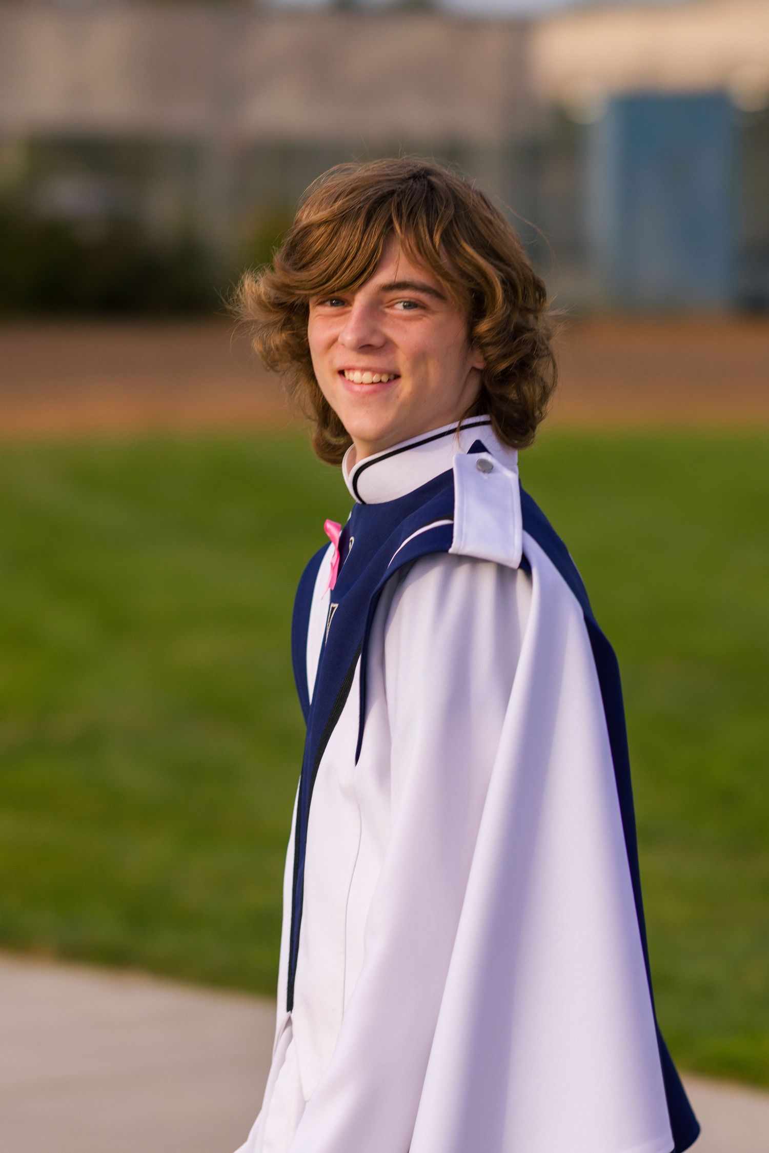 A person wearing a navy and white reversible sports jacket stands outdoors in a series of poses showing different angles.