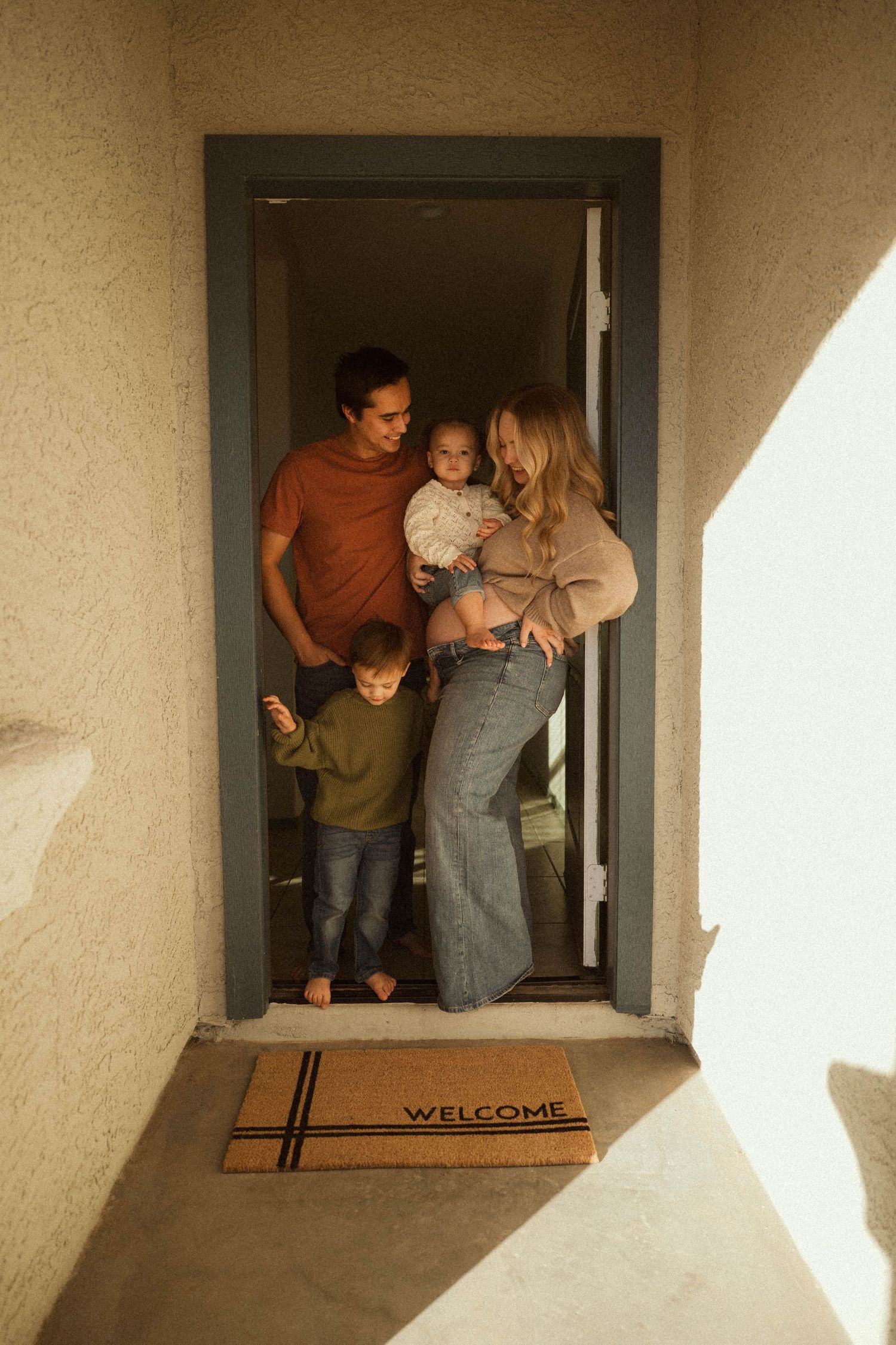 A series of photos showing people sitting and peering out of a window with a welcome mat below.