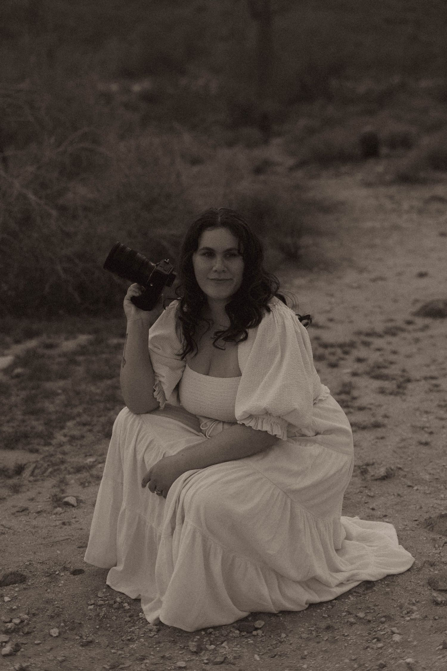 A black and white photo series showing a person in a flowing white dress reclining on the ground in different poses.