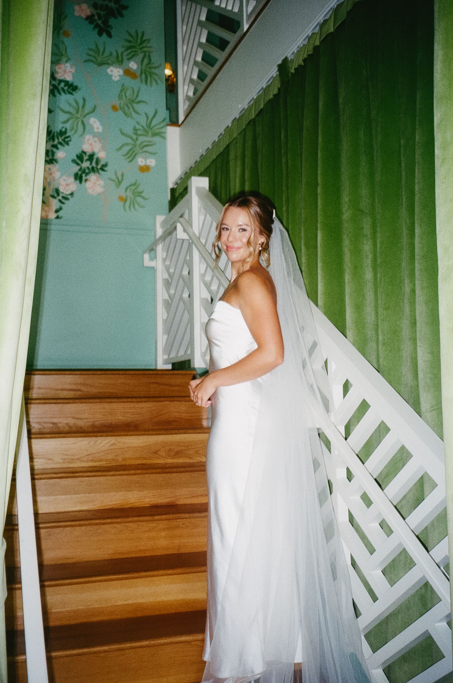 Series of wedding dress photos on wooden stairs with green curtains and floral wallpaper in the background.