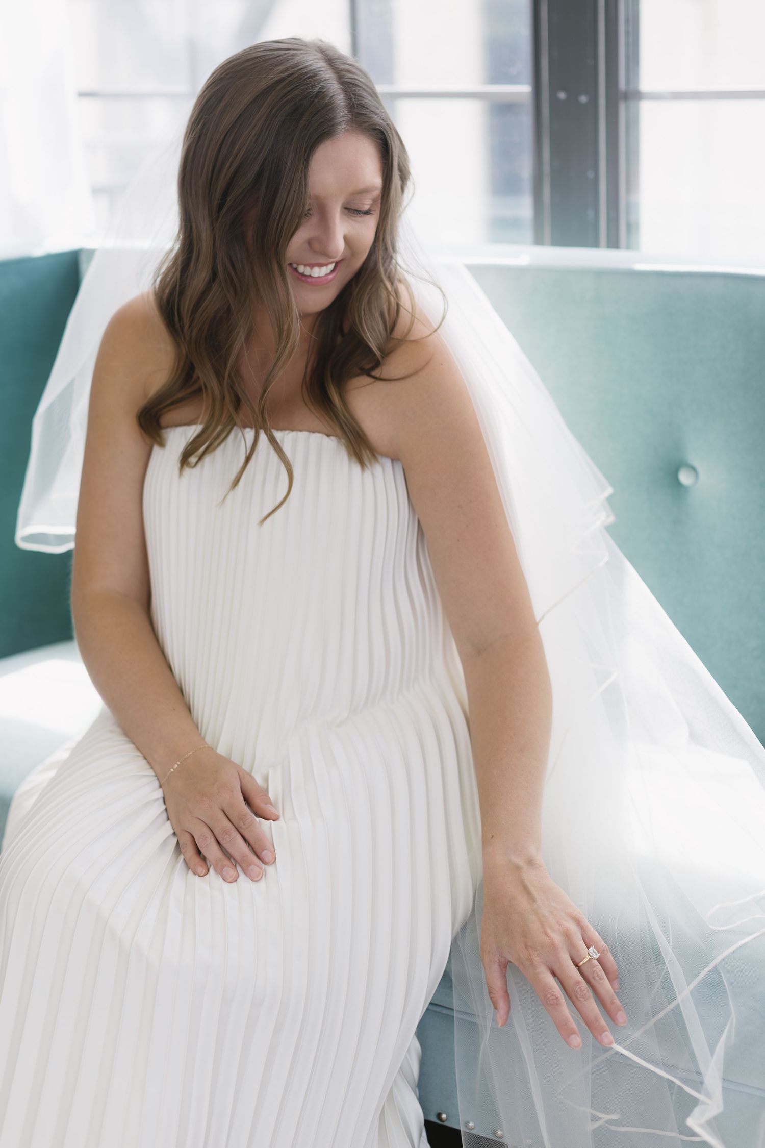 Elegant white pleated dress captured in soft natural window light.