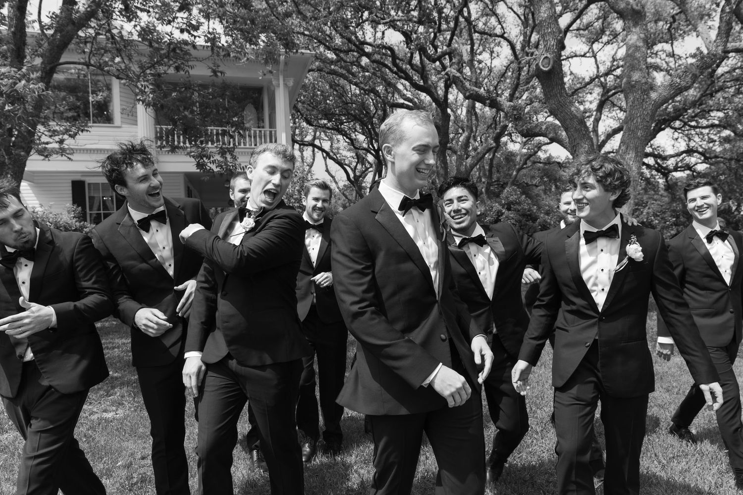 Black and white photo sequence of groomsmen posing playfully outdoors under large trees.