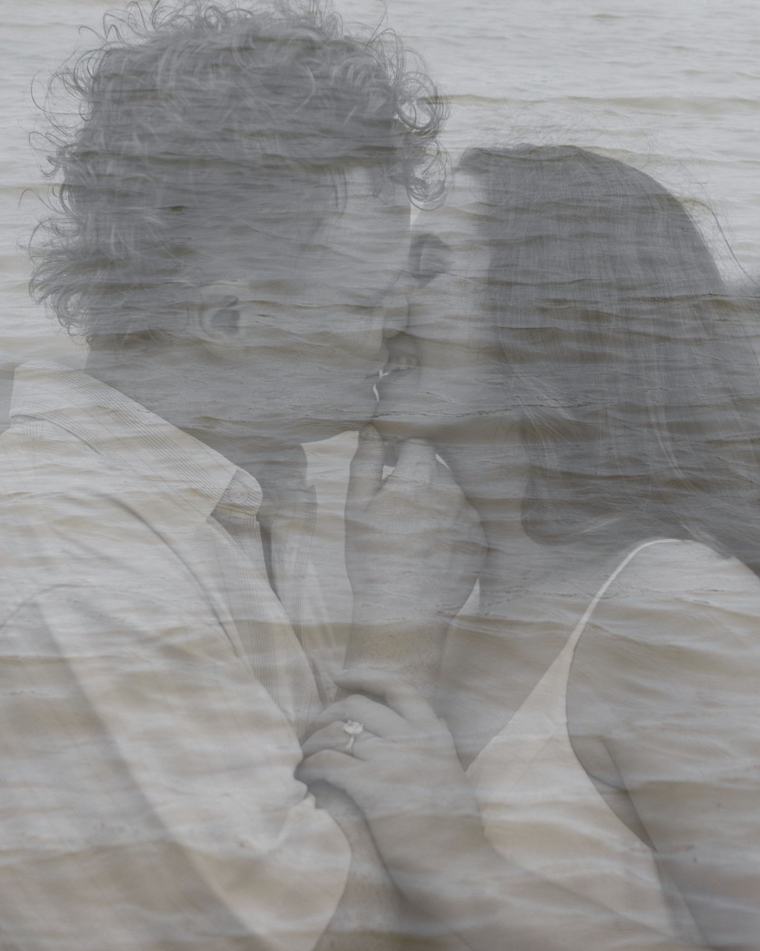 Dreamy black and white double exposure of a romantic couple by the water.