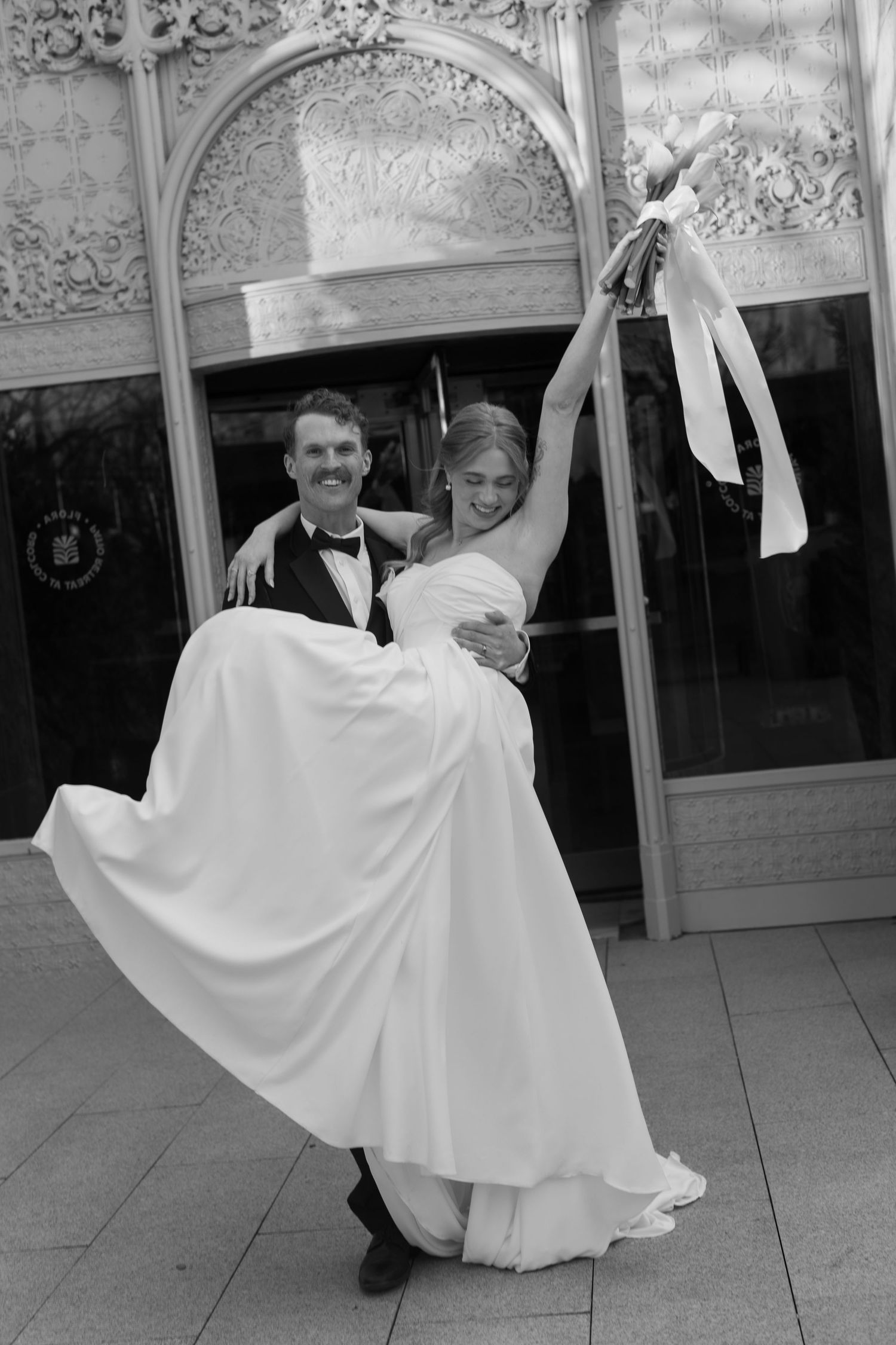 Black and white photos of playful wedding couple dancing on ornate patio.