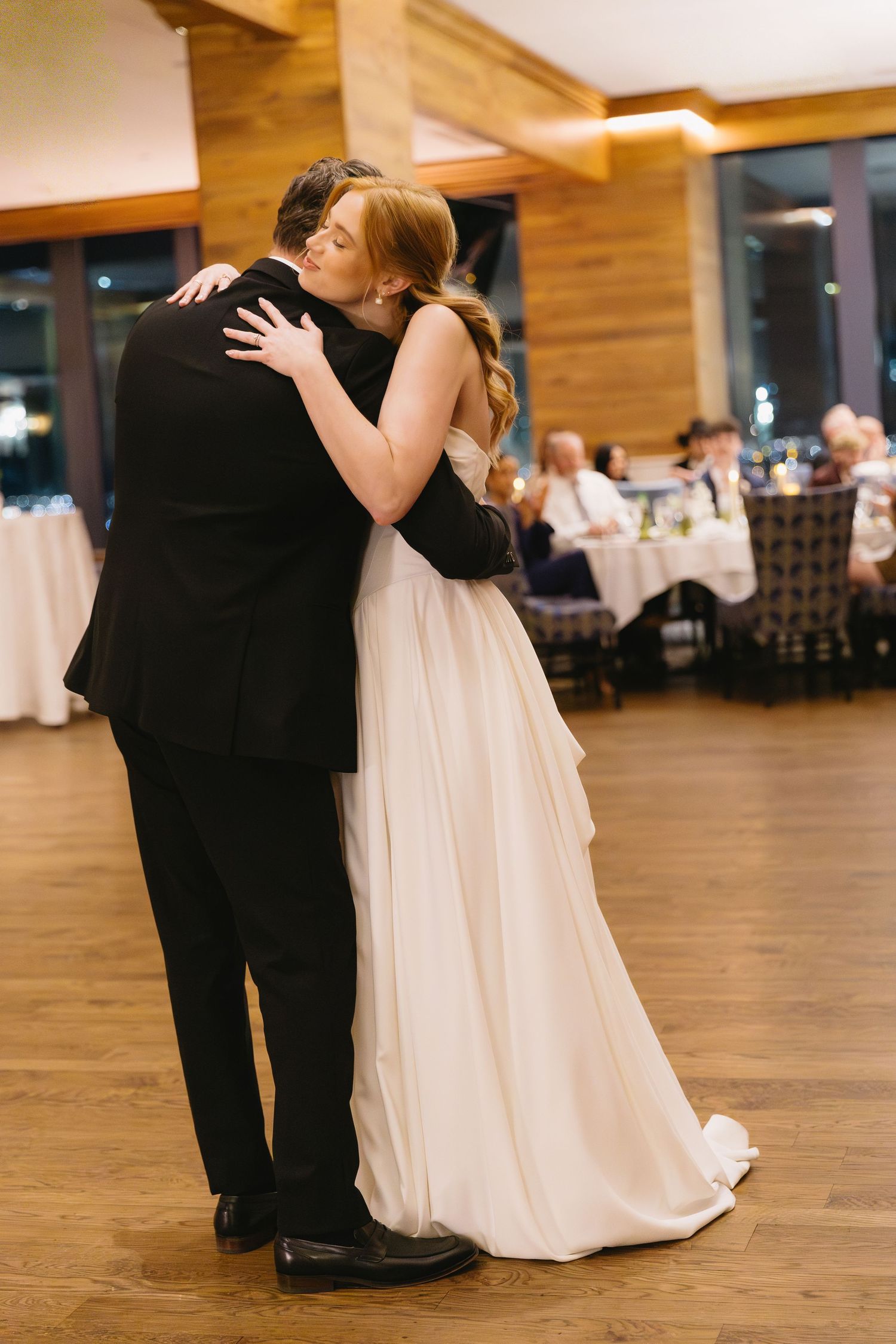 Couples dancing on a wooden floor at an elegant reception venue.