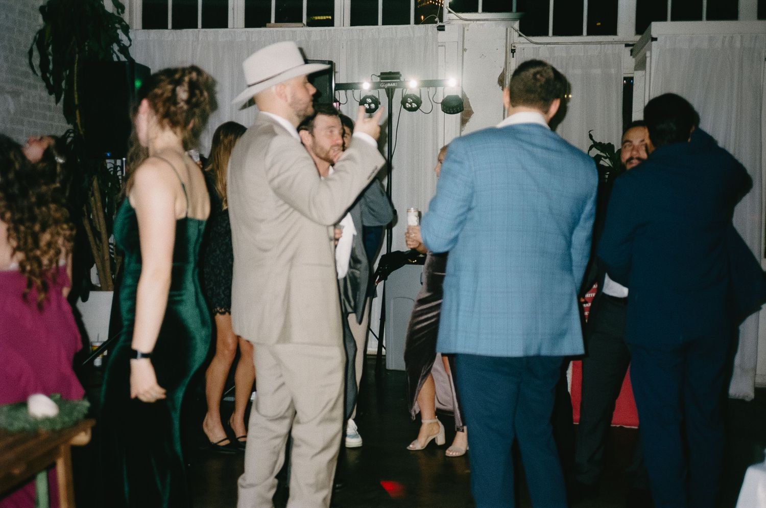 Wedding reception dance floor filled with guests in formal attire.