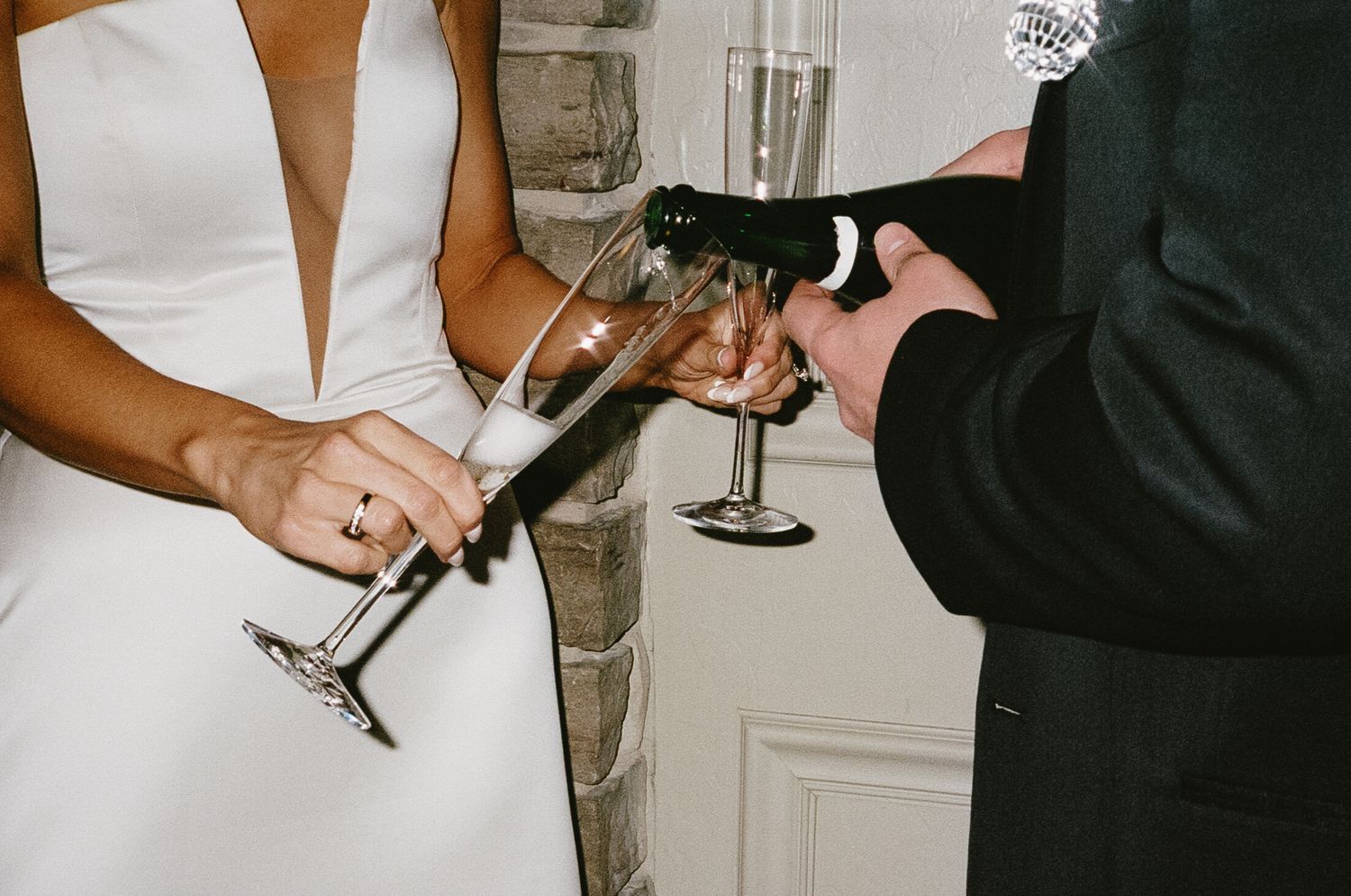 Hands holding champagne glasses in a celebratory toast at an elegant event.